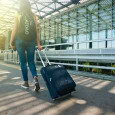 woman with a backpack and suitcase on wheels