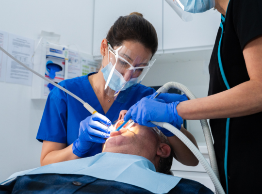 implant dentist performing a dental checkup