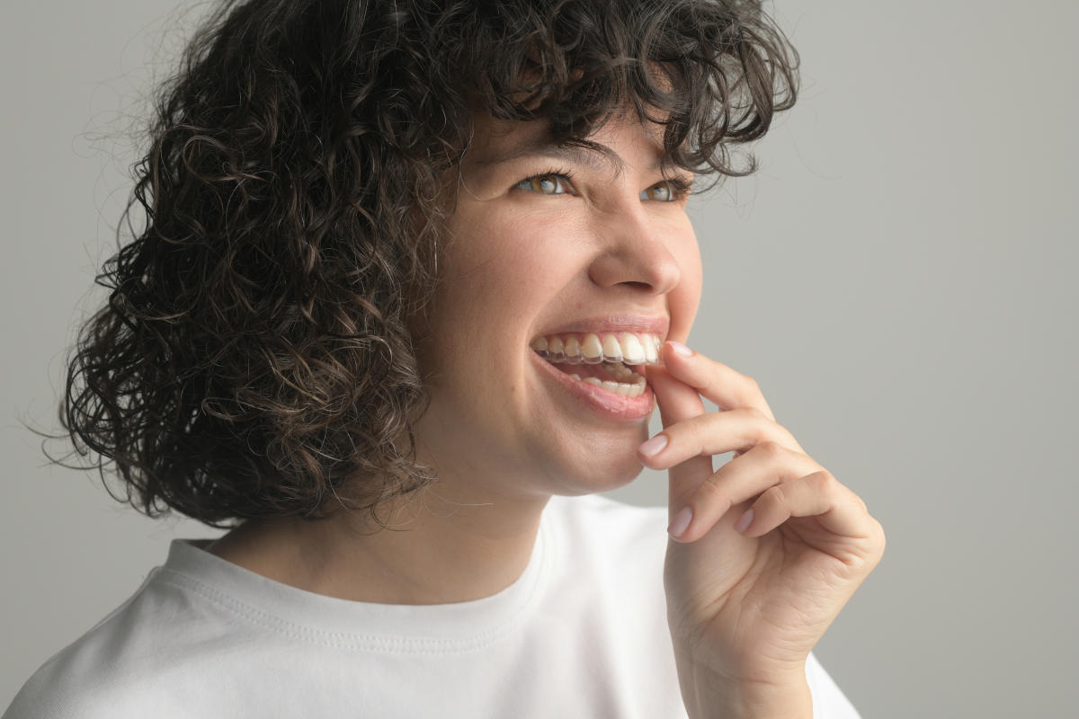 woman putting in clear aligners