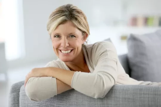 Smiling woman sitting on a sofa.